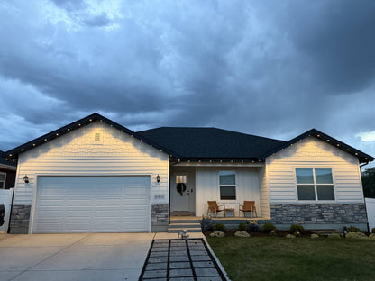 Full home elevation at dusk with warm white lights running every eave and gable