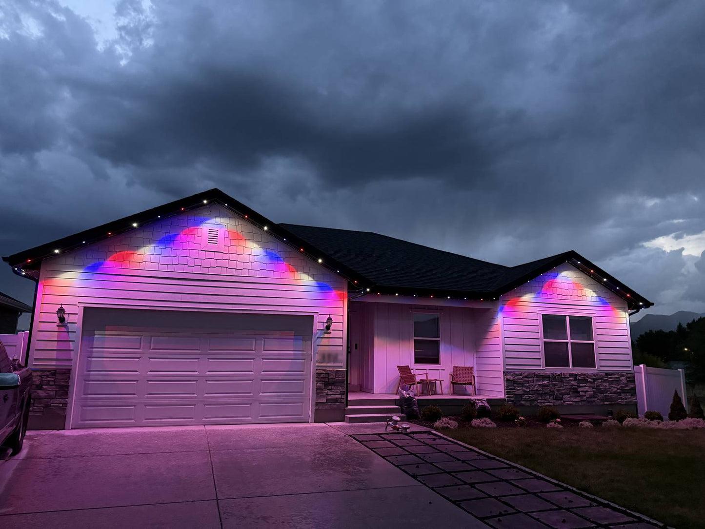 The same home at dusk lit in red, white and blue